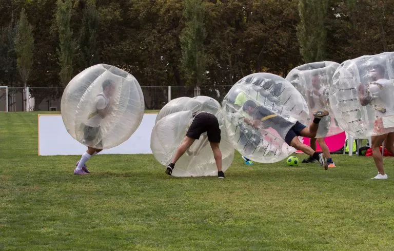 Groupe jouant au football à bulles