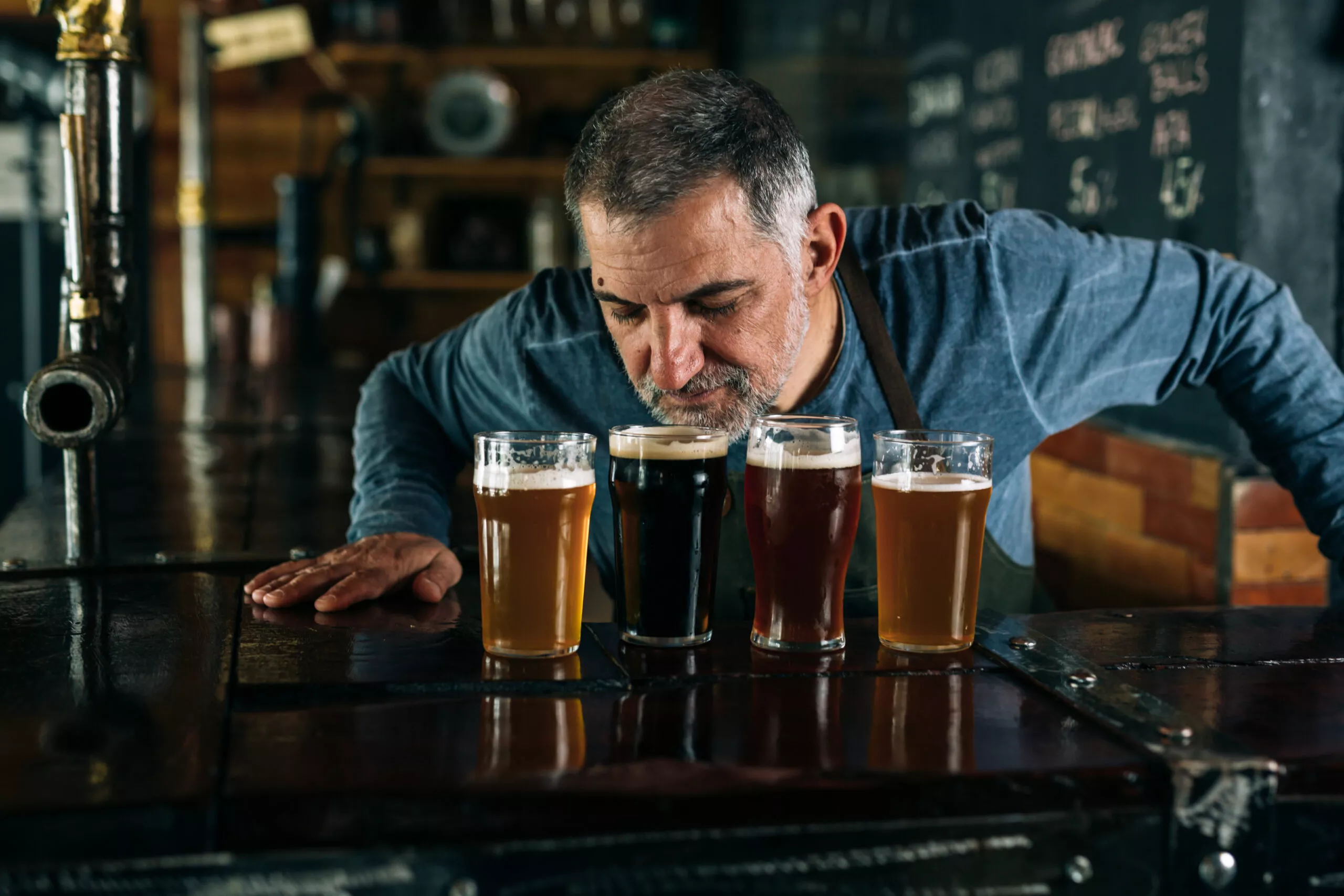 Barkeeper riecht an einem Bier in einer Bar