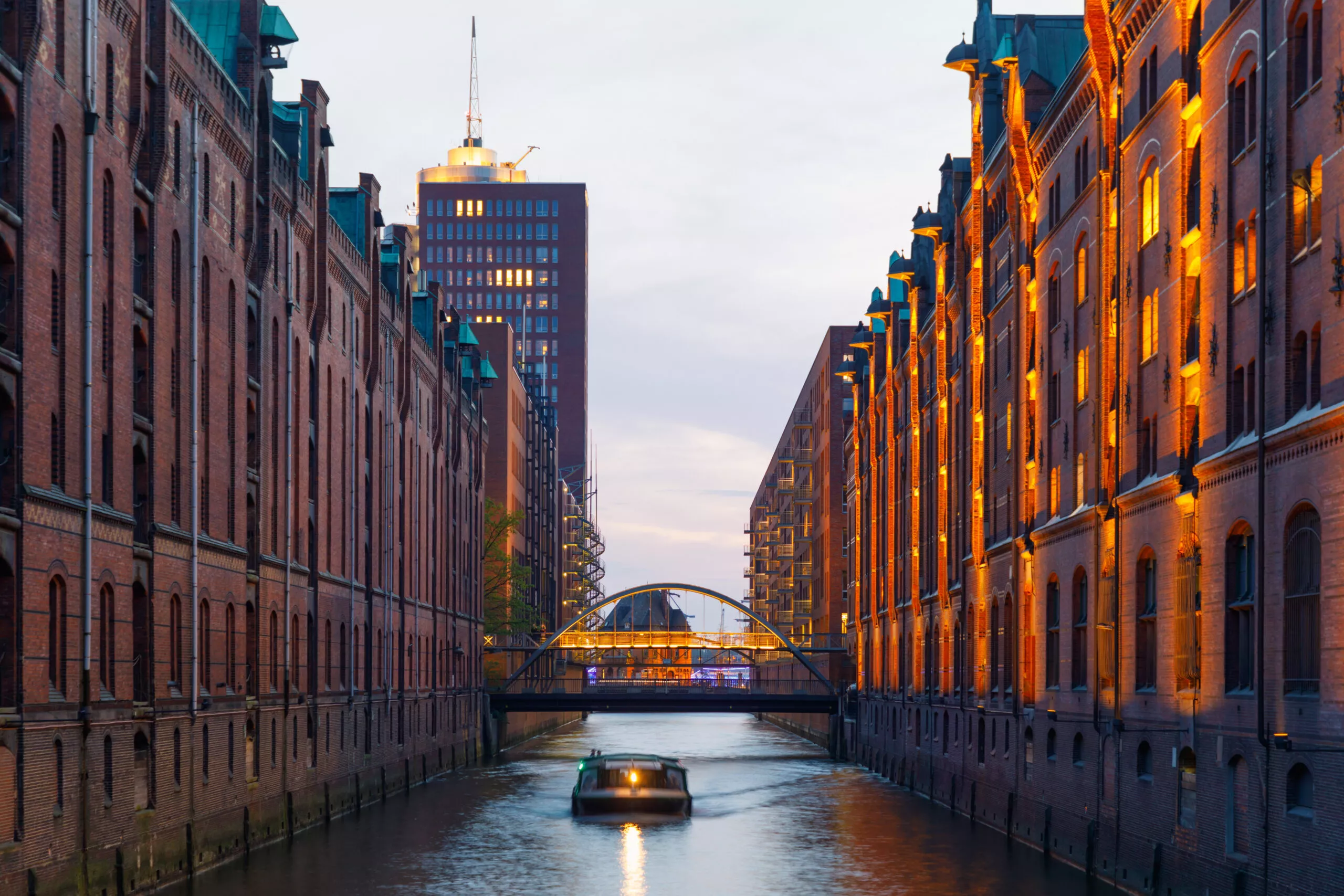 Boot im Kanal in der historischen Speicherstadt in Hamburg bei Sonnenuntergang