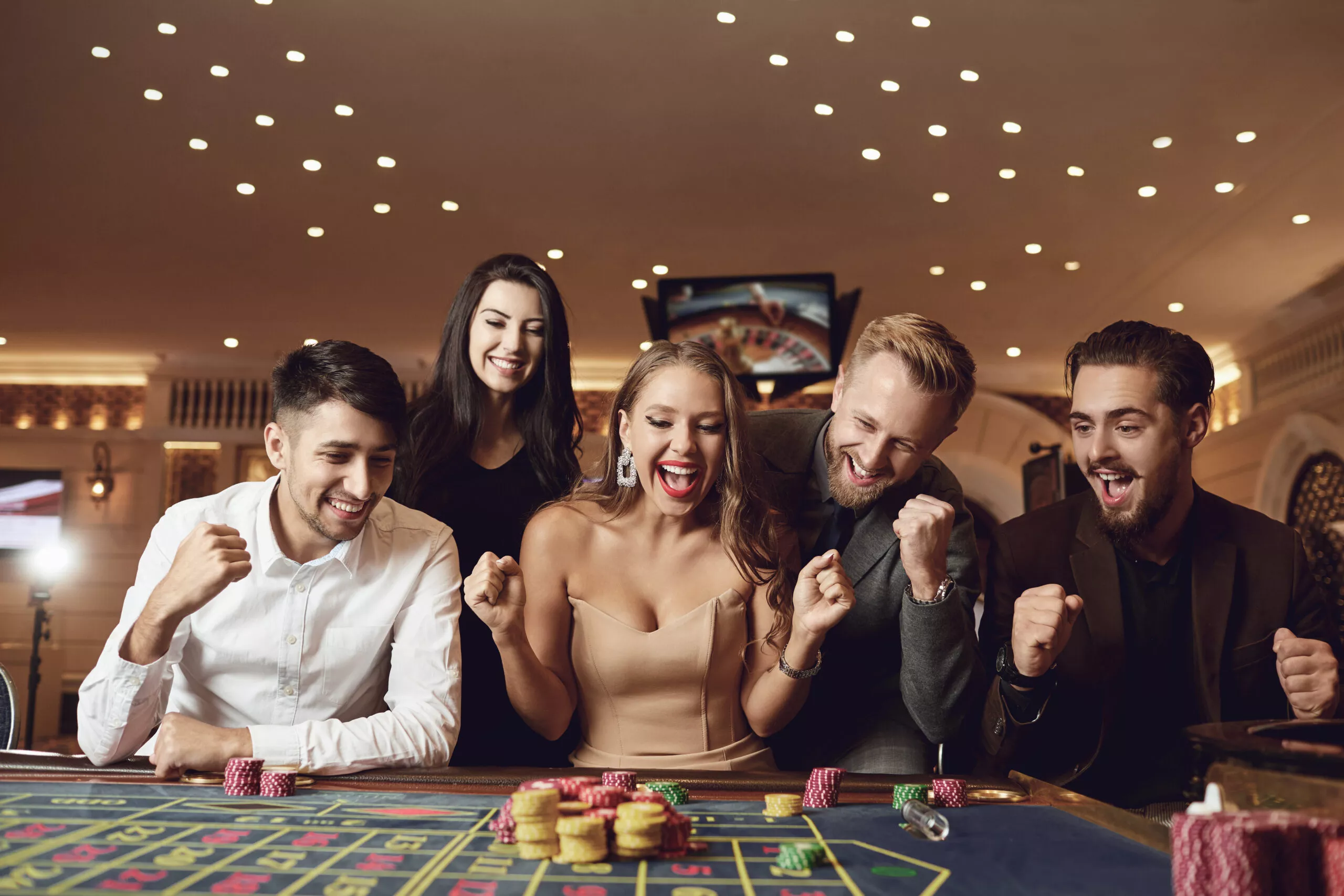 Des gens heureux parient à la roulette ou au poker dans un casino.
