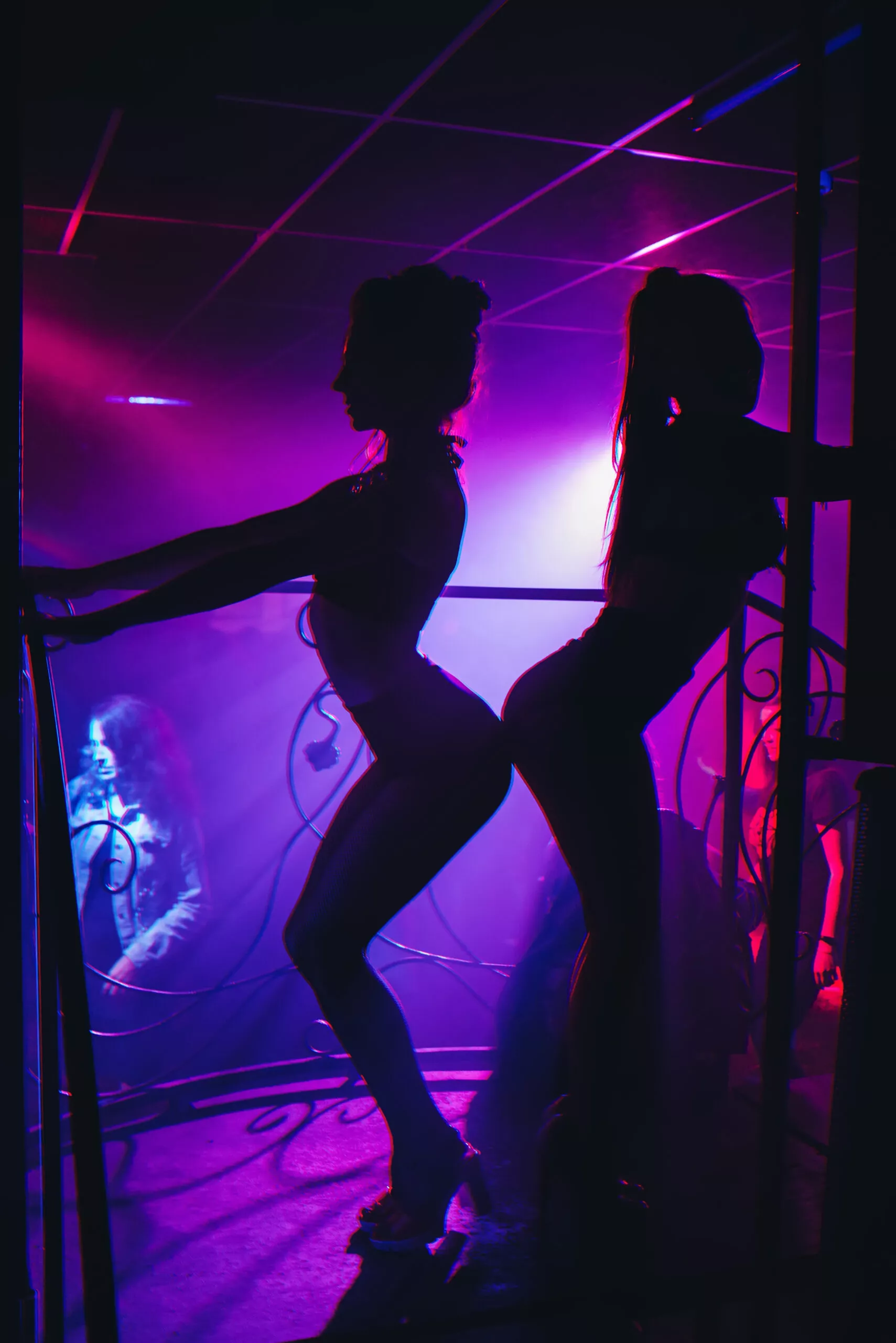 slanke meisjesdanseres in een nachtclub die op het podium poseert