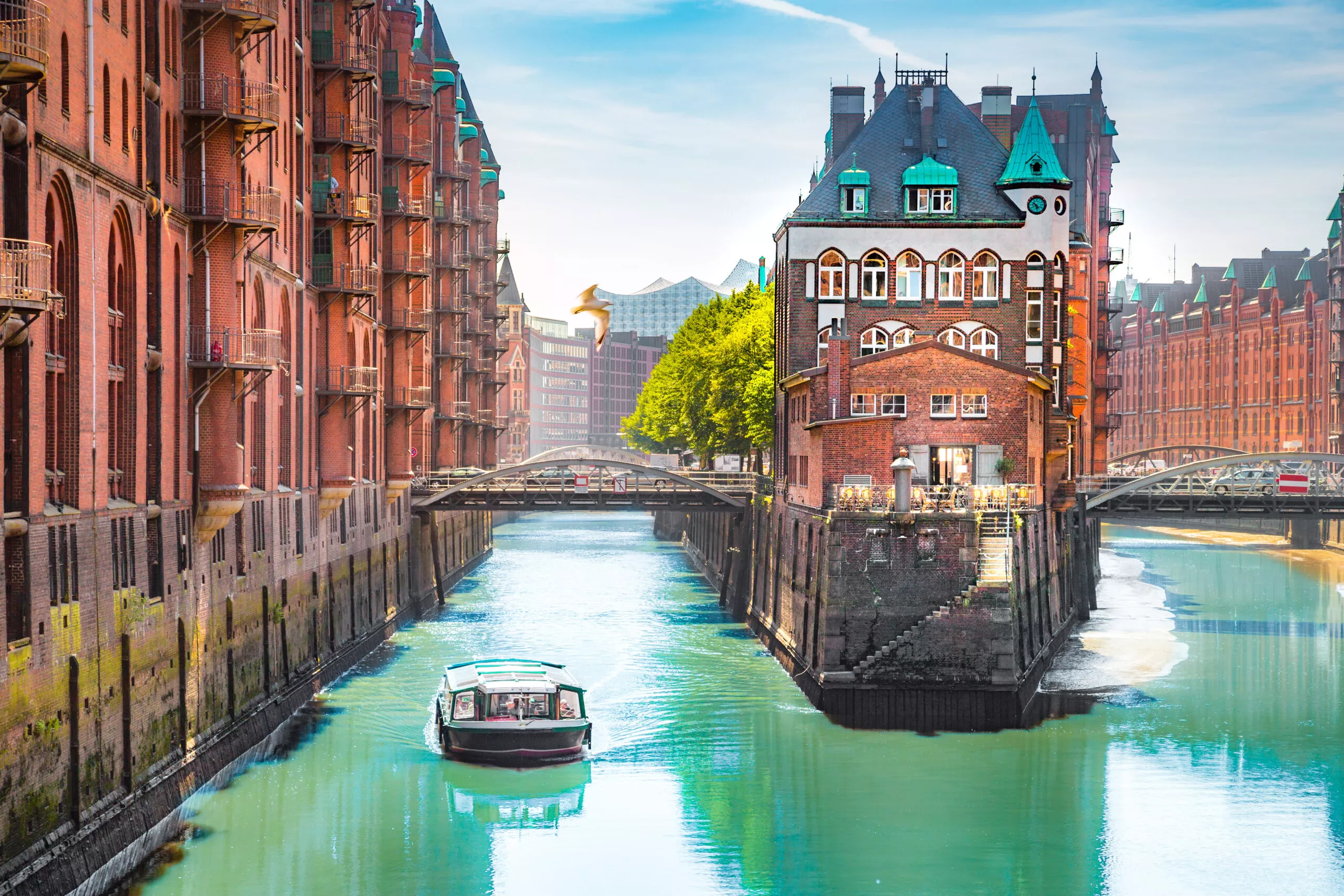 Barrio portuario Speicherstadt de Hamburgo con barco turístico en verano, Alemania