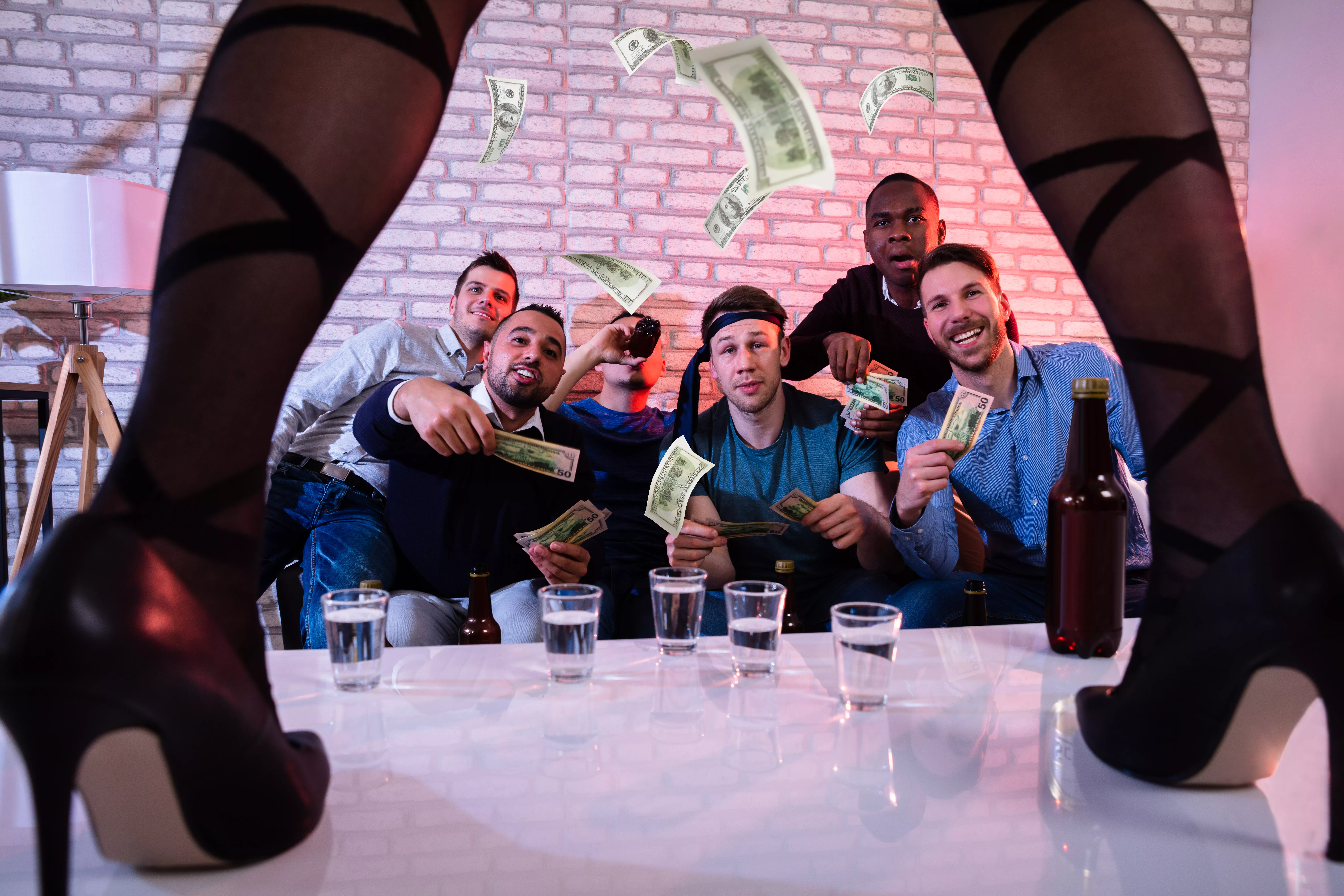 Männliche Freunde bieten der Stripperin auf der Bühne Geld an