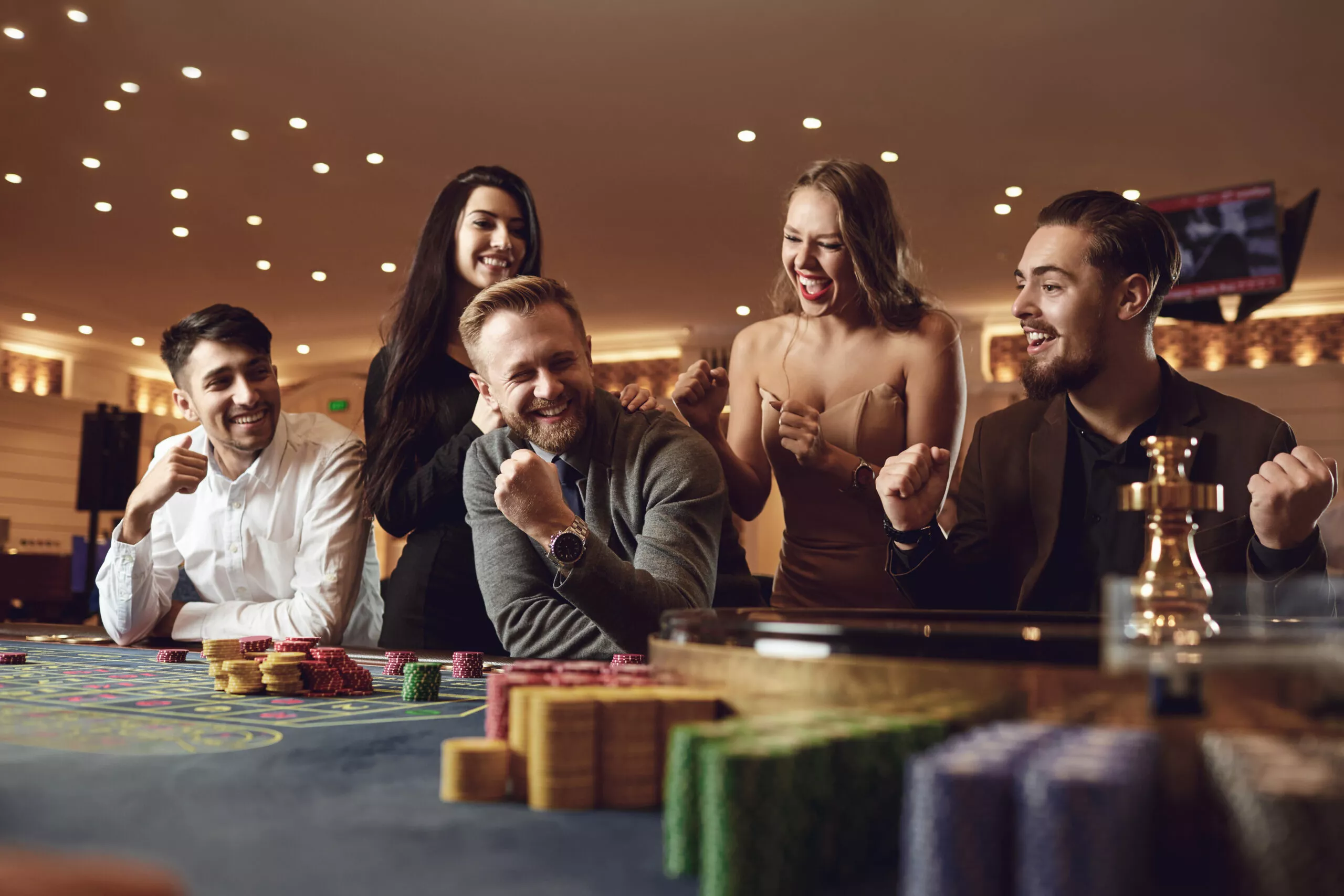 Le persone felici scommettono nel gioco d'azzardo alla roulette poker in un casinò